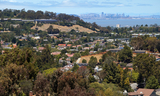 Aerial view of Belmont Hills overlooking homes with the San Francisco Bay in the distance