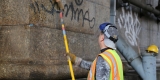 Worker cleaning graffiti