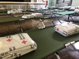 Disaster shelter cots and red cross blankets